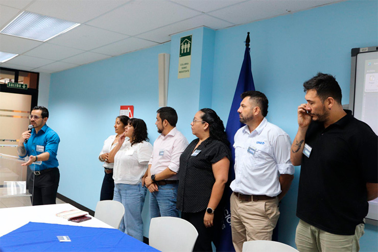 La imagen muestra un grupo de 7 personas entre hombres y mujeres, todos de pie, uno de ellos con un micrófono en la mano, son autoridades universitarias participando de la jornada de diálogo.